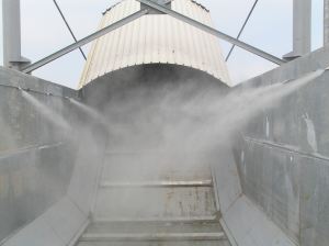 Nastro trasportatore per rifiuti ZC2114 in aggetto sul mare per carico chiatte, vista della zona di scarico interrata in buca. Ugelli nebulizzatori per abbattimento polveri.
